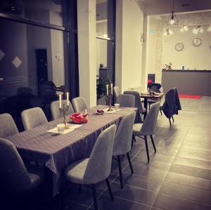 a dining room with a long table and chairs at Pensiunea CASA SPANDO in Mărişel
