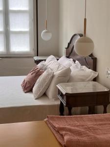 a bedroom with a bed with white pillows and a table at Pensao O Laranjeira in Viana do Castelo