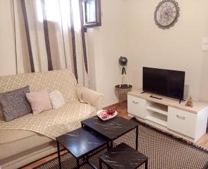 - un salon avec un canapé et une télévision dans l'établissement Elegant apartment, à Thessalonique