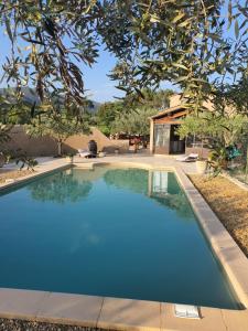 a large blue swimming pool in front of a house at Villa L'Estagniol in Lourmarin