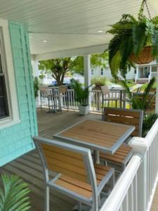a deck with a table and chairs on a house at Saltwater Inn in Belmar
