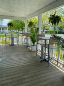 a covered porch with tables and chairs and a plant at Saltwater Inn in Belmar