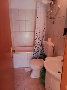 a bathroom with a toilet and a tub and a sink at Ana Apartments in Vis +21 photos