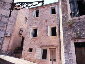 um antigo edifício de tijolos com janelas e uma porta em Ana Apartments em Vis