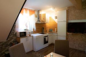 een kleine keuken met witte kasten en een raam bij Appartement Edelweiss mit Infrarotkabine in Großsölk