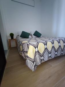 um quarto com uma cama com um edredão estampado em Joli T2 rénové et calme Quartier desrochers à Fort de France em Fort-de-France
