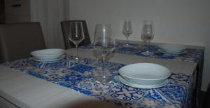 a table with wine glasses and plates on a table at Four Seasons Summer Room in Cefalù +7 photos