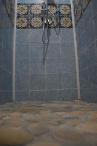 a shower in a bathroom with a tile wall at Four Seasons Summer Room in Cefalù