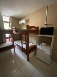 a room with two bunk beds with a computer and a desk at Apraiana Hostel in Recife