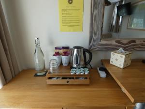a wooden table with a coffee maker and bottles on it at The Sloop Inn in Kingsbridge