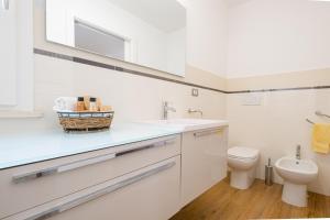 een witte badkamer met een toilet en een wastafel bij Chiara & Giulia Apartments by HDSalento in Leuca