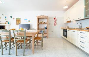 een keuken met een tafel en stoelen en een wastafel bij Chiara & Giulia Apartments by HDSalento in Leuca