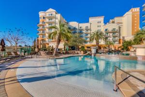 a swimming pool at a resort with palm trees and buildings at Marina Inn 4-501 in Myrtle Beach