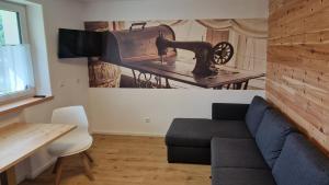 a living room with a couch and a picture of a sewing machine at Ferienwohnung Schnalstal " Die Schneiderei " in Senales