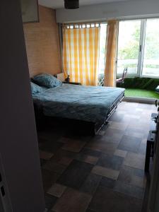 a bedroom with a bed and a large window at Studio proche gare centre ville in Pau