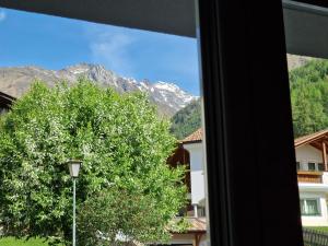 a window with a view of a tree and mountains at Ferienwohnung Schnalstal " Die Schneiderei " in Senales