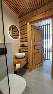 a bathroom with two sinks and a wooden wall at Tuia Apartment in Pärnu