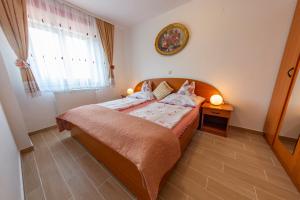 a bedroom with a bed and a clock on the wall at Apartments Anita in Pula