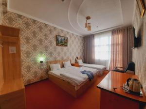 a bedroom with a bed and a desk with a telephone at Зона отдых APACHI в горах ЧИМГАН in Chimgan +140 photos