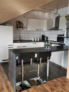 een keuken met een zwarte bar met 2 barkrukken bij Apartment Hasselstrasse in Mehren