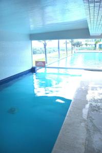 een zwembad met blauw water in een gebouw bij Salinas Resorts Exclusive, Premium e Park - Elcias Silva in Salinópolis