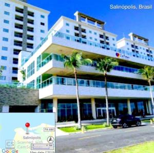 a large building with palm trees in front of it at Salinas Resorts Exclusive, Premium e Park - Elcias Silva in Salinópolis