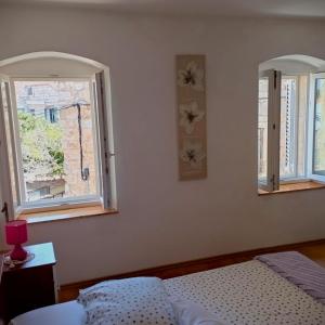 ein Schlafzimmer mit zwei Fenstern und einem Bett darin in der Unterkunft Ana Apartments in Vis