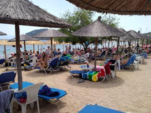 un grupo de personas sentadas en sillas en una playa en Blue Oasis Maisonette, en Nea Iraklitsa