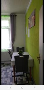 ein Esszimmer mit einem Tisch, Stühlen und einem Fenster in der Unterkunft Ferienwohnung Hesse in Grimma