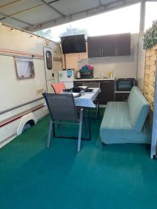 an rv with a table and chairs in a kitchen at Sunny House Caravans in Sozopol