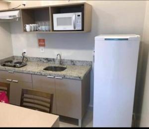 a small kitchen with a sink and a microwave at Salinas park 2/4 in Salinópolis +2 photos