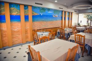 a restaurant with tables and chairs and a painting on the wall at Sangiovanni in Shëngjin
