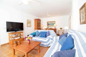 uma sala de estar com um sofá e uma mesa em Global Properties, Precioso apartamento con terraza y vistas al mar em Canet d'En Berenguer