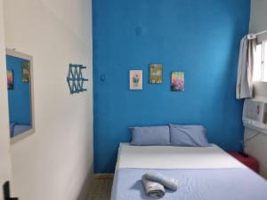 Casa do Meio Pousada في ريسيفي: غرفة زرقاء مع سرير بجدار ازرق