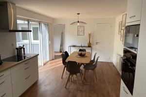 uma cozinha e sala de jantar com mesa e cadeiras em LE POULORIO TERRASSE - T3 RDC - 2 salles de douches ByLocly em Lorient