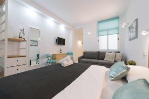 ein Schlafzimmer mit einem großen Bett und einem Sofa in der Unterkunft MCD Roca Studio in Las Palmas de Gran Canaria