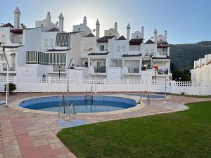 a large white building with a pool in front of it at Casa del olivo in Almuñécar