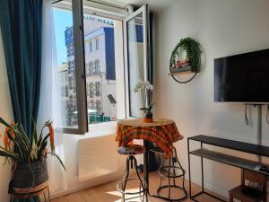 a living room with a table and a window at LA GRANV'ILLAISE in Granville