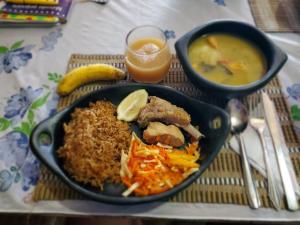 a table with a plate of food and a bowl of soup at Posada El Esfuerzo in Nuquí