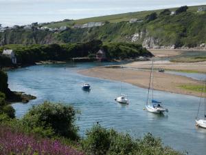 a group of boats in a river with a beach at The Sloop Inn in Kingsbridge