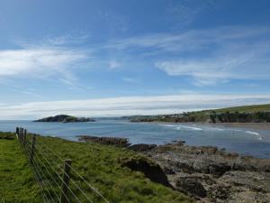 a view of a beach with a fence and the ocean at The Sloop Inn in Kingsbridge