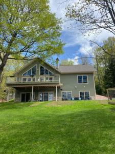 ein großes Haus mit einer Veranda und einem großen Hof in der Unterkunft Crescent Lakehouse - Surf, Ski and Serenity in Iron River