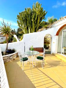 eine Terrasse mit einem Tisch, Stühlen und einem Zaun in der Unterkunft Hill Top House Mountain Views Moraira in Moraira