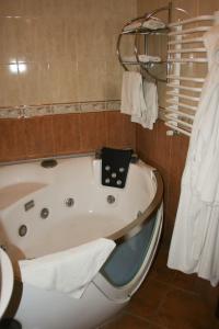 a bath room with a tub and a toilet at Don Kihot Hotel in Novovolynsʼk