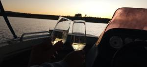 Twee mensen houden champagneglazen op een boot. bij Pedacinho do Paraiso in CÃ¡ssia