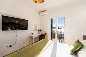 ein Schlafzimmer mit einem Bett und einem TV an der Wand in der Unterkunft Ponte Apartment in Orasac