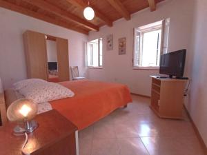 a bedroom with a bed and a television in it at Ana Apartments in Vis