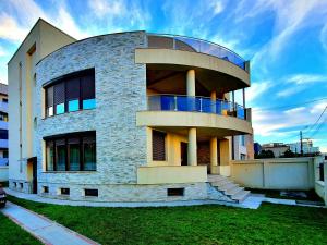 a building with a round building with a balcony at Casa Maria Mamaia Nord in Mamaia Sat/Năvodari