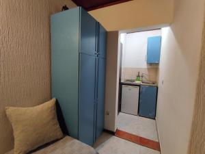 a small kitchen with a blue cabinet in a room at Vojinovic Apartments in Budva