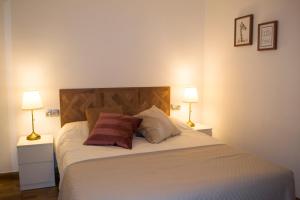 sypialnia z dużym łóżkiem z 2 lampami w obiekcie Apartamenticos Torrenueva I w Saragossie